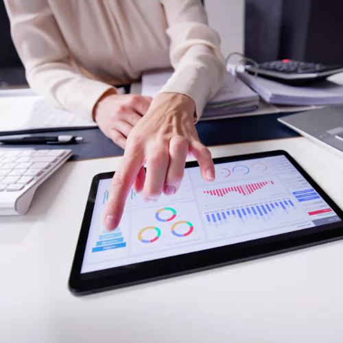 Business professional analyzing charts and graphs on a tablet, representing industry data and market insights.