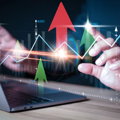 Rising financial charts with green and red arrows on a laptop screen, symbolizing market growth and investment trends.