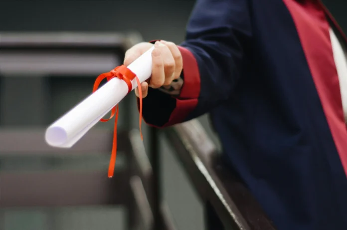 Scholarship diploma held by graduate in academic gown