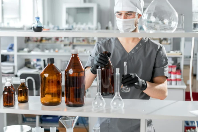Lab technician handling raw materials in a coatings ingredients database setting