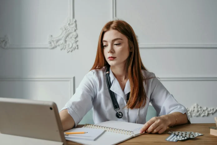 Healthcare professional reviewing data related to the FDA 510(k) database on a digital device.