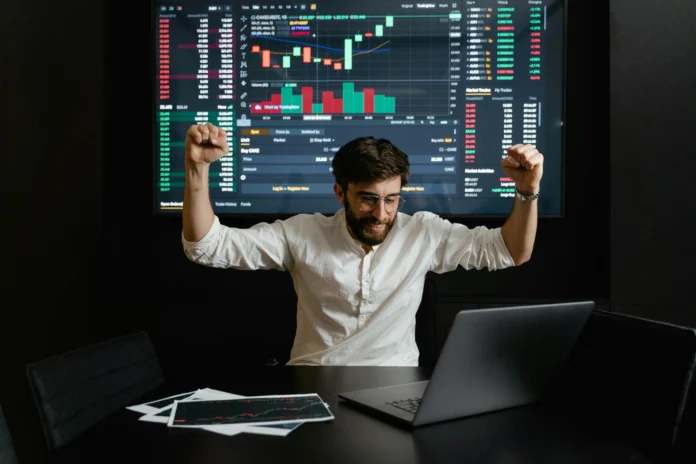 Entrepreneur celebrating in front of investment dashboard – Free Investors Database for Fundraising