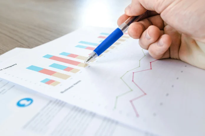 Person analyzing printed health data charts with a pen – illustration for the CDC WONDER Database and its use in public health research.