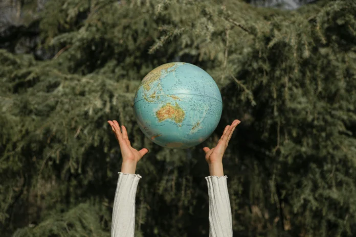 International Climate Finance Database concept – A person holds a globe representing global responsibility and climate investment efforts.