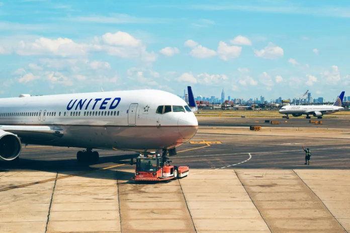 United Airlines aircraft at Newark Liberty International Airport taxiing near terminal, illustrating the concept of the TravelingWiki airport database.