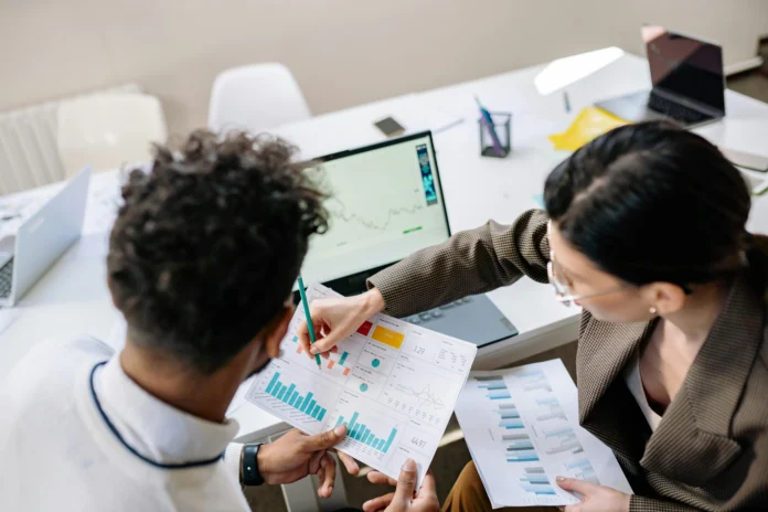 Two professionals reviewing business data and charts, illustrating the process of using the New Hampshire Business Entity Search to analyze company records.