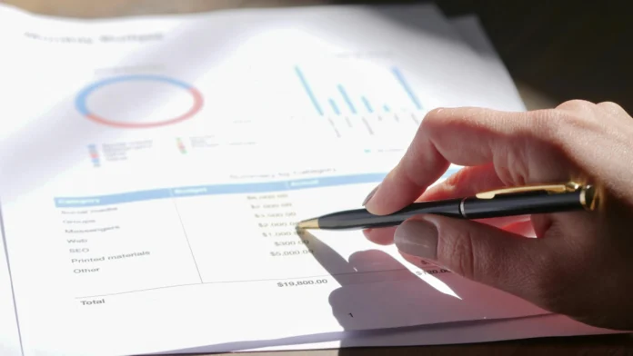 Person analyzing business registration data with charts and figures, related to North Carolina Business Entity Search.