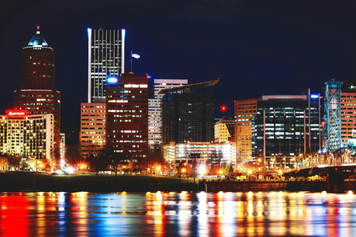 Night view of downtown Portland, Oregon, with city lights reflecting on the river — symbolic backdrop for the Oregon Business Entity Search.