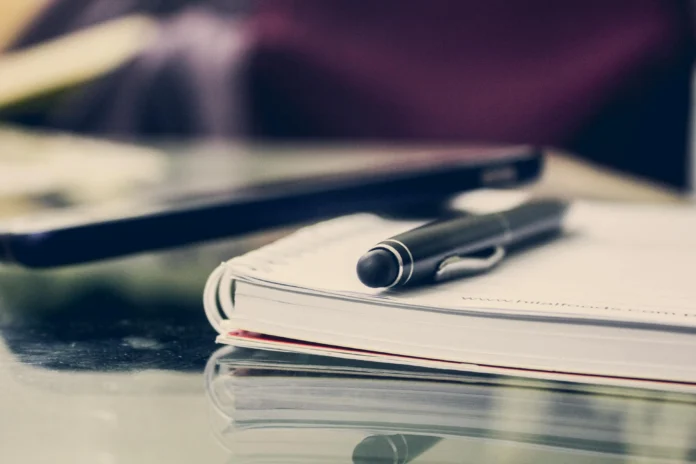 A notebook and pen on a desk, symbolizing documentation and transparency in the EPA Guidance Database.