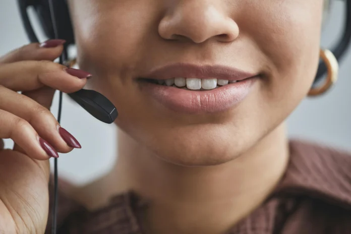 Close-up of a call center worker with a headset, symbolizing phone providers’ compliance efforts tracked in the Robocall Mitigation Database.