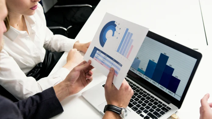 “Professionals analyzing charts and graphs representing SEC Statistics and Data Visualizations on paper and laptop.