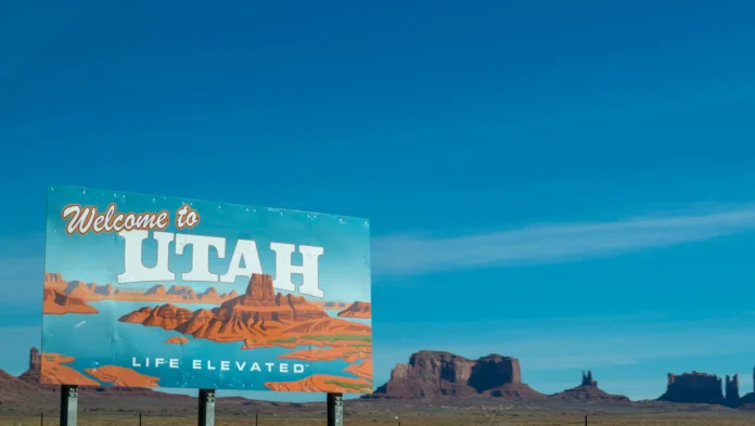 Utah Business Entity Search illustration with a ‘Welcome to Utah’ highway sign and desert landscape in the background.