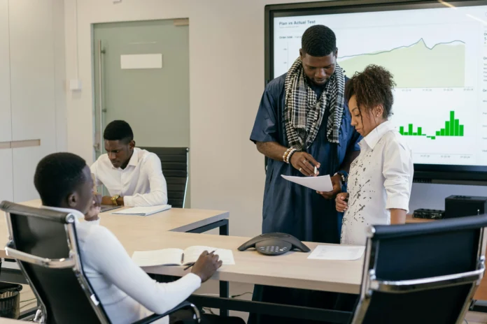Business professionals reviewing documents and data charts during a meeting, representing the process of using the Virgin Islands Business Entity Search for company verification.