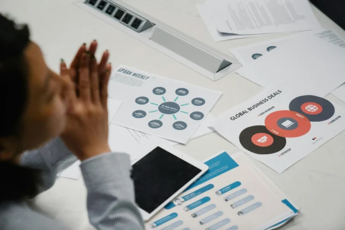 Business documents and charts on a desk, illustrating how the Wisconsin Business Entity Search helps analyze company records and status.