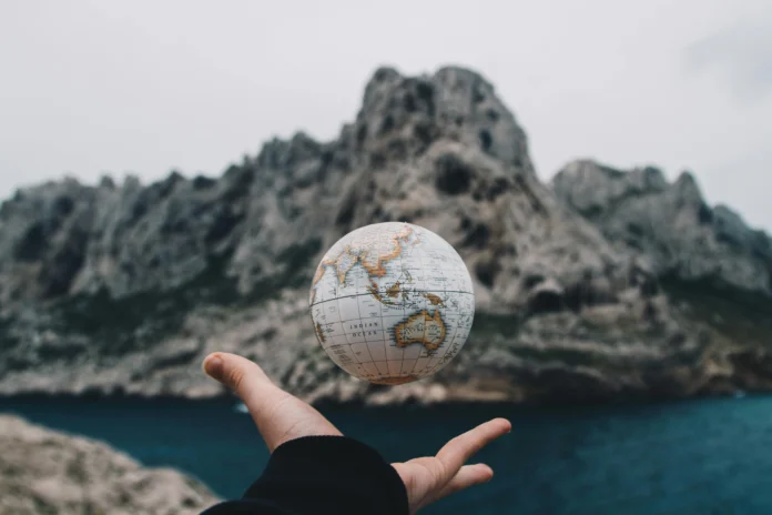 A hand holding a small globe, symbolizing global digital trade and international regulation — representing the Digital Trade Regulatory Readiness Database.
